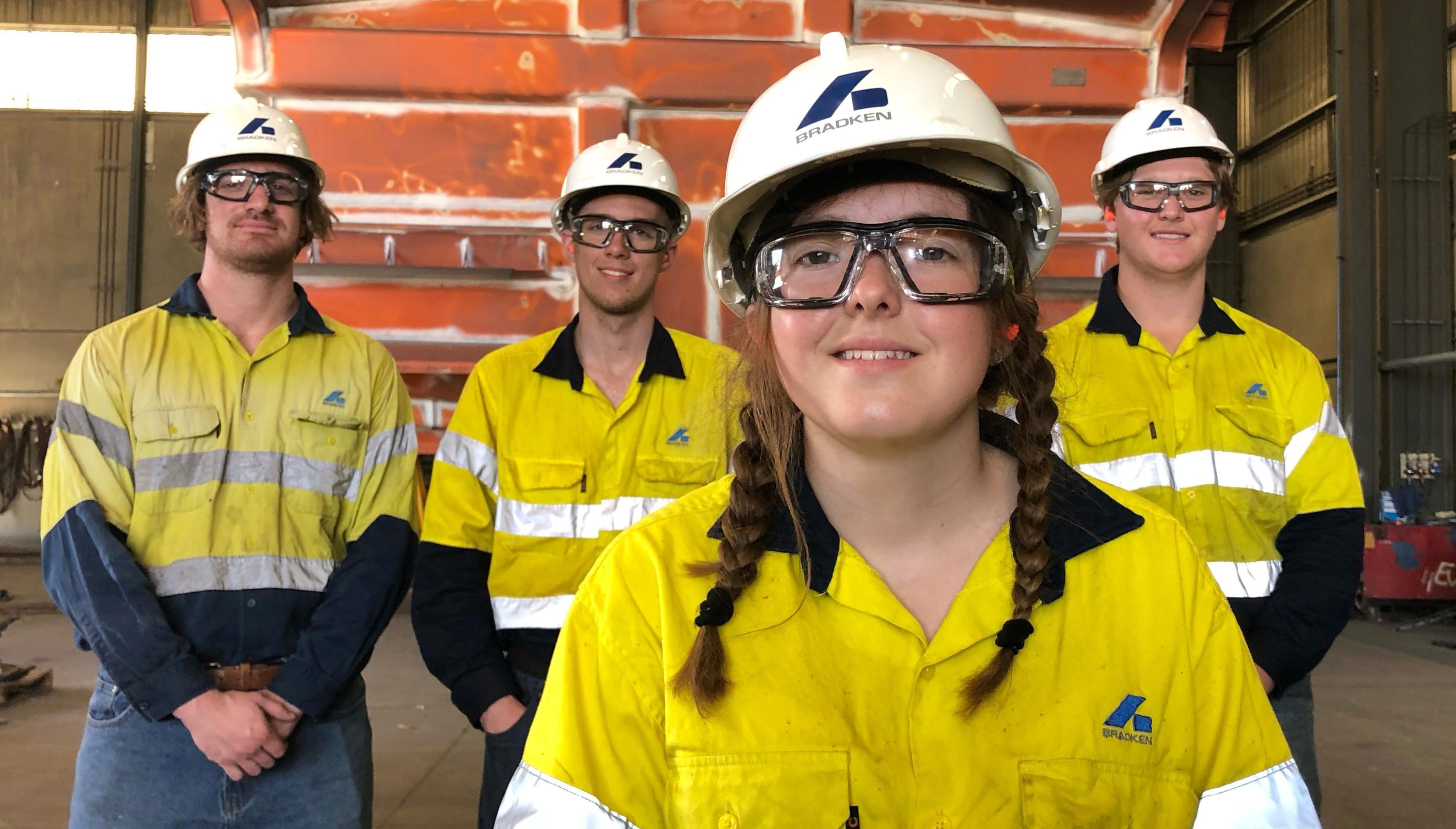 1st and 4th year boilermaker apprentices, three male one female, wearing yellow hi-vis shirts with the Bradken logo on them